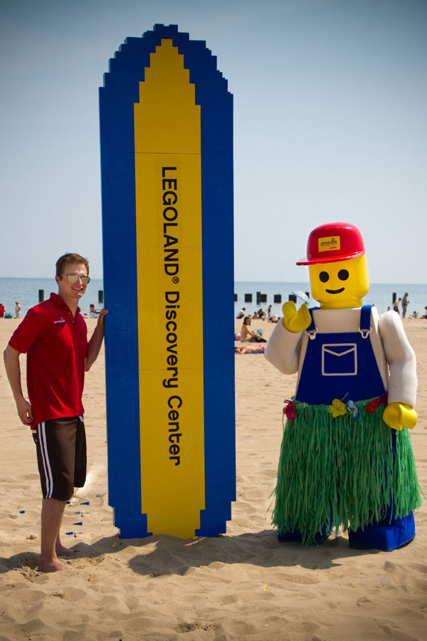 Master model builder and LEGO Buddy complete 12-foot surfboard made out of 30,000 LEGO bricks. (PRNewsFoto/LEGOLAND Discovery Center, Laura Dajoraite)